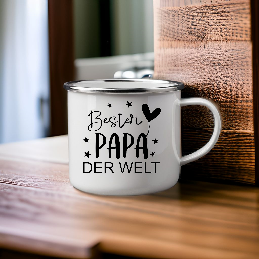 Weiße Emaille-Tasse mit schwarzem Aufdruck „Bester Papa der Welt“, steht auf einem Holztisch – ideales Geschenk für Väter, handgefertigt und langlebig.